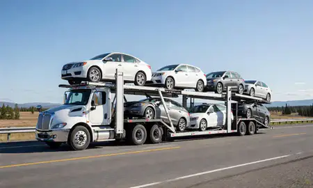 Multi-level car carrier on the highway to Meadow Lakes, Alaska, United States
