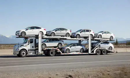 Multi-level car carrier on the highway to South Lakes, Alaska, United States