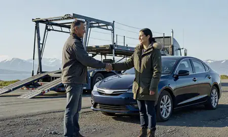 Vehicle owner beside their delivered car in Valdez, Alaska, United States