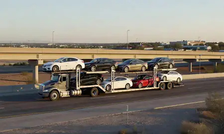 Car transporter with the Maricopa, Arizona, United States skyline behind it