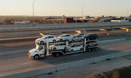 Car transporter with the Marion, Arkansas, United States skyline behind it