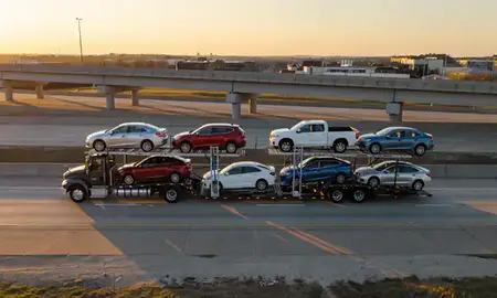 Car transporter with the Russellville, Arkansas, United States skyline behind it