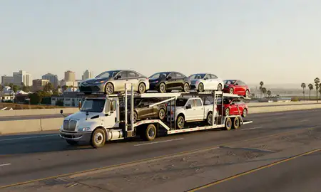 Car transporter with the Oxnard, California, United States skyline behind it
