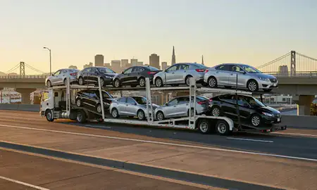 Car transporter with the San Francisco, California, United States skyline behind it