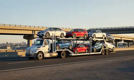 Car transporter with the Stockton, California, United States skyline behind it