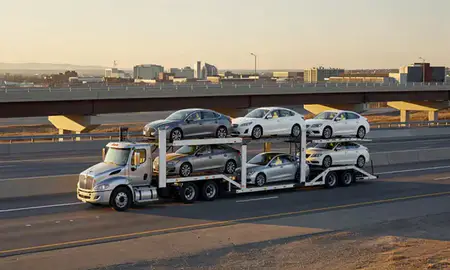 Car transporter with the Centennial, Colorado, United States skyline behind it