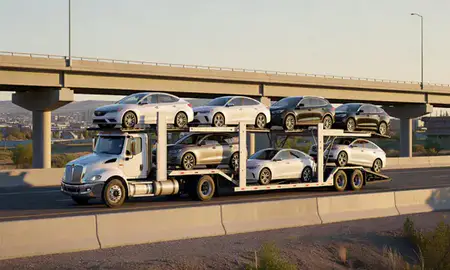 Car transporter with the Lakewood, Colorado, United States skyline behind it