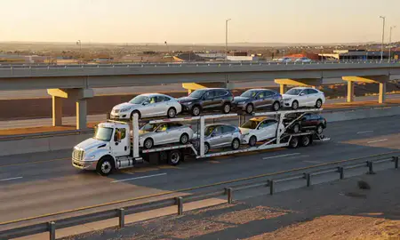 Car transporter with the Pueblo West, Colorado, United States skyline behind it