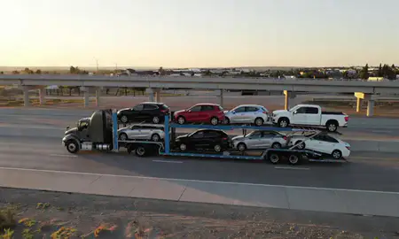 Car transporter with the Security-Widefield, Colorado, United States skyline behind it