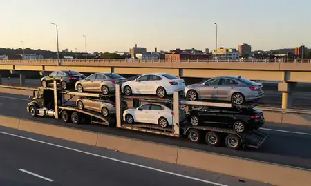 Car transporter with the Milford city, Connecticut, United States skyline behind it