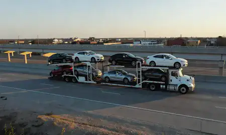 Car transporter with the Smyrna, Delaware, United States skyline behind it