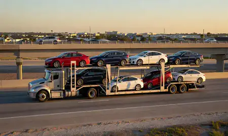 Car transporter with the Lehigh Acres, Florida, United States skyline behind it