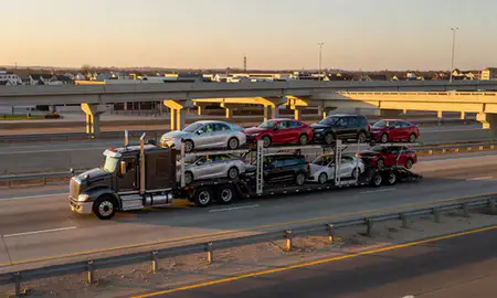 Car transporter with the Mableton, Georgia, United States skyline behind it