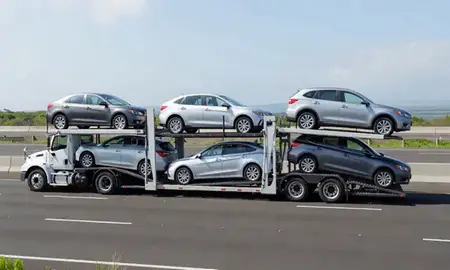 Multi-level car carrier on the highway to Ewa Gentry, Hawaii, United States