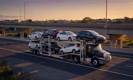 Car transporter with the Makakilo, Hawaii, United States skyline behind it