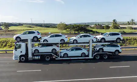 Multi-level car carrier on the highway to Mililani Mauka, Hawaii, United States