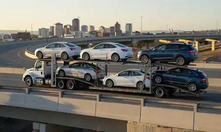 Car transporter with the Boise, Idaho, United States skyline behind it