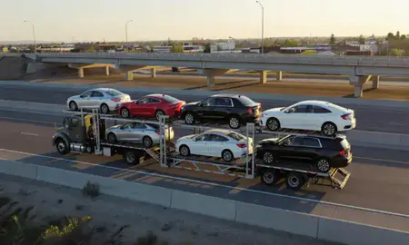 Car transporter with the Chubbuck, Idaho, United States skyline behind it