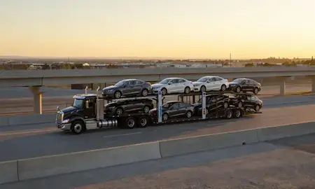 Car transporter with the Hayden, Idaho, United States skyline behind it