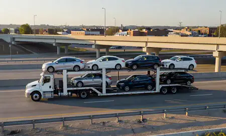 Car transporter with the Berwyn, Illinois, United States skyline behind it