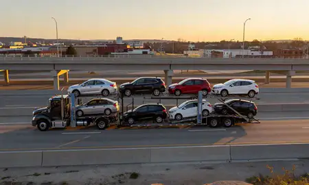 Car transporter with the Mount Prospect, Illinois, United States skyline behind it