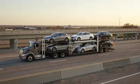Car transporter with the Tinley Park, Illinois, United States skyline behind it