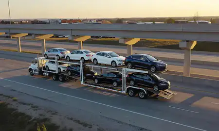 Car transporter with the Noblesville, Indiana, United States skyline behind it