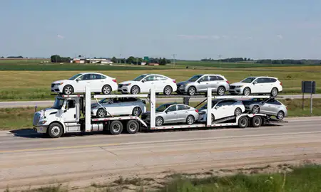 Multi-level car carrier on the highway to Altoona, Iowa, United States