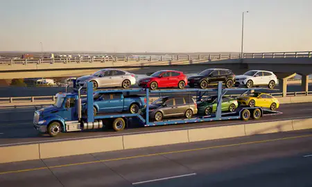 Car transporter with the Bettendorf, Iowa, United States skyline behind it