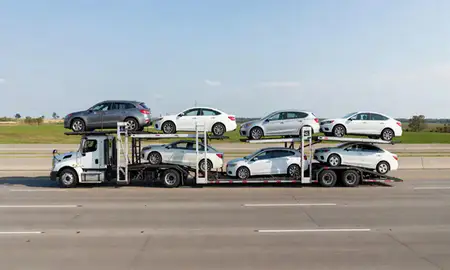 Multi-level car carrier on the highway to Clinton, Iowa, United States