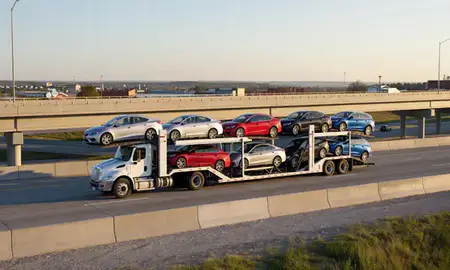Car transporter with the Marion, Iowa, United States skyline behind it