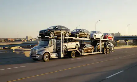 Car transporter with the West Des Moines, Iowa, United States skyline behind it
