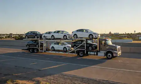 Car transporter with the Hays, Kansas, United States skyline behind it