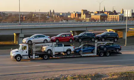 Car transporter with the Lawrence, Kansas, United States skyline behind it