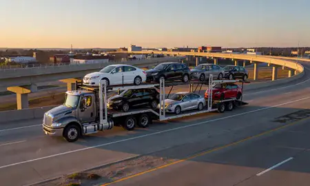 Car transporter with the Hopkinsville, Kentucky, United States skyline behind it