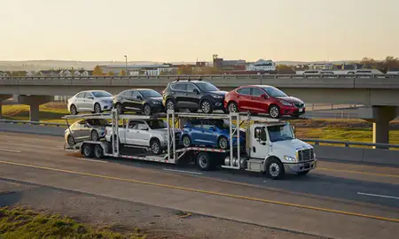 Car transporter with the Radcliff, Kentucky, United States skyline behind it