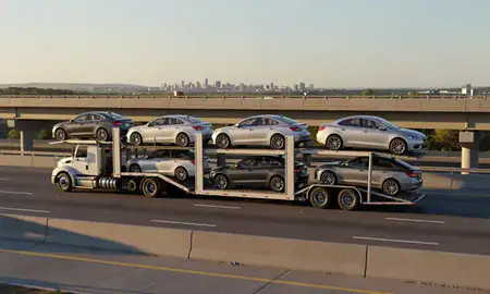Car transporter with the Maine, United States skyline behind it