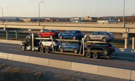 Car transporter with the Caribou, Maine, United States skyline behind it