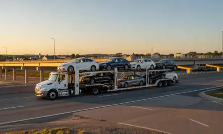Car transporter with the South Berwick, Maine, United States skyline behind it