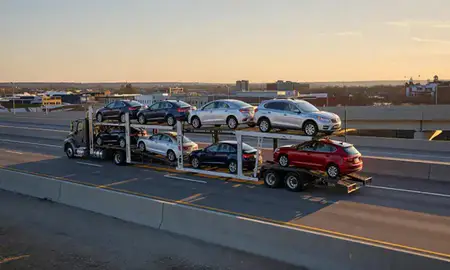 Car transporter with the Framingham, Massachusetts, United States skyline behind it