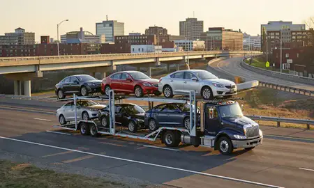 Car transporter with the Worcester, Massachusetts, United States skyline behind it