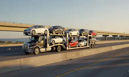 Car transporter with the Muskegon, Michigan, United States skyline behind it