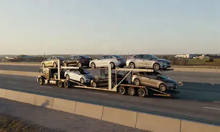 Car transporter with the South Lyon, Michigan, United States skyline behind it