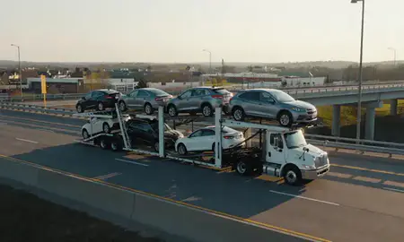 Car transporter with the Inver Grove Heights, Minnesota, United States skyline behind it