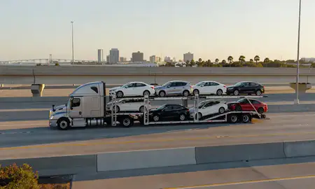 Car transporter with the Biloxi, Mississippi, United States skyline behind it