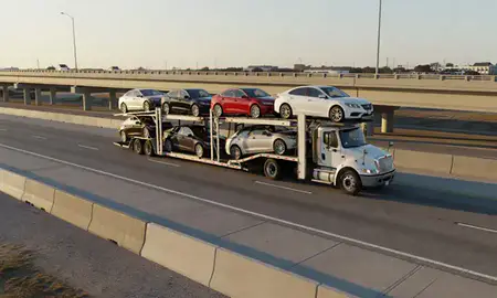 Car transporter with the D'Iberville, Mississippi, United States skyline behind it