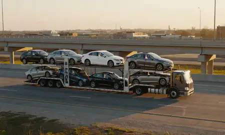 Car transporter with the Madison, Mississippi, United States skyline behind it