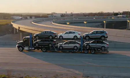 Car transporter with the Liberty, Missouri, United States skyline behind it