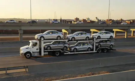 Car transporter with the Maryland Heights, Missouri, United States skyline behind it