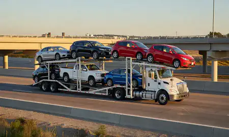Car transporter with the St. Peters, Missouri, United States skyline behind it